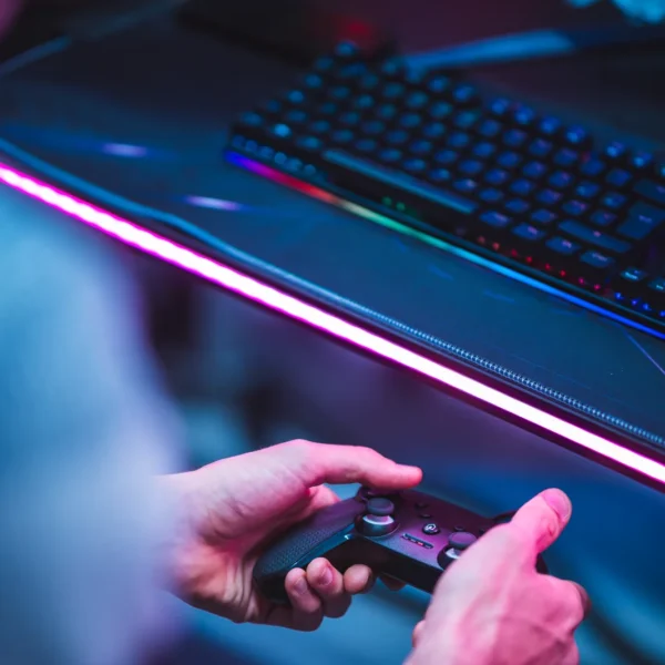Mani sul controller davanti a una postazione gaming RGB alla Game Arena di Olbia