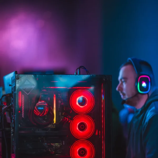 PC gaming con ventole RGB e giocatore con cuffie alla Game Arena di Olbia